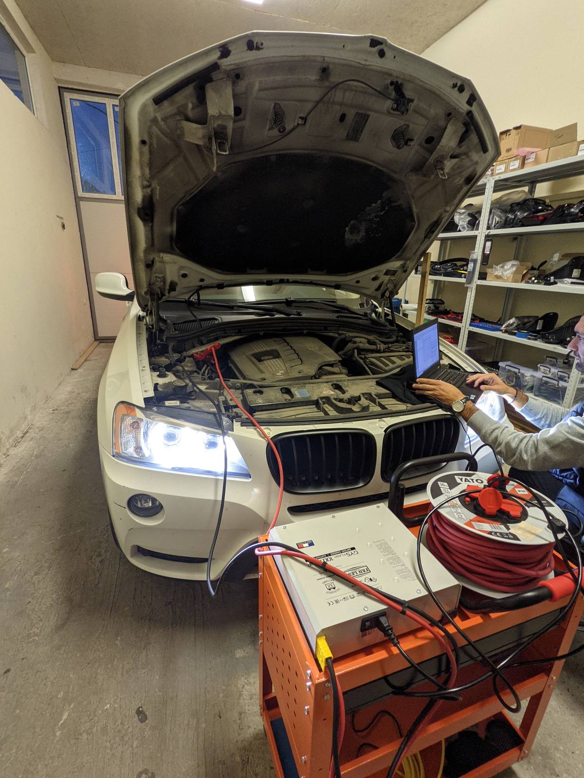 The X3 with the bonnet open in the workshop, laptop on the wing and the power supply on a cart