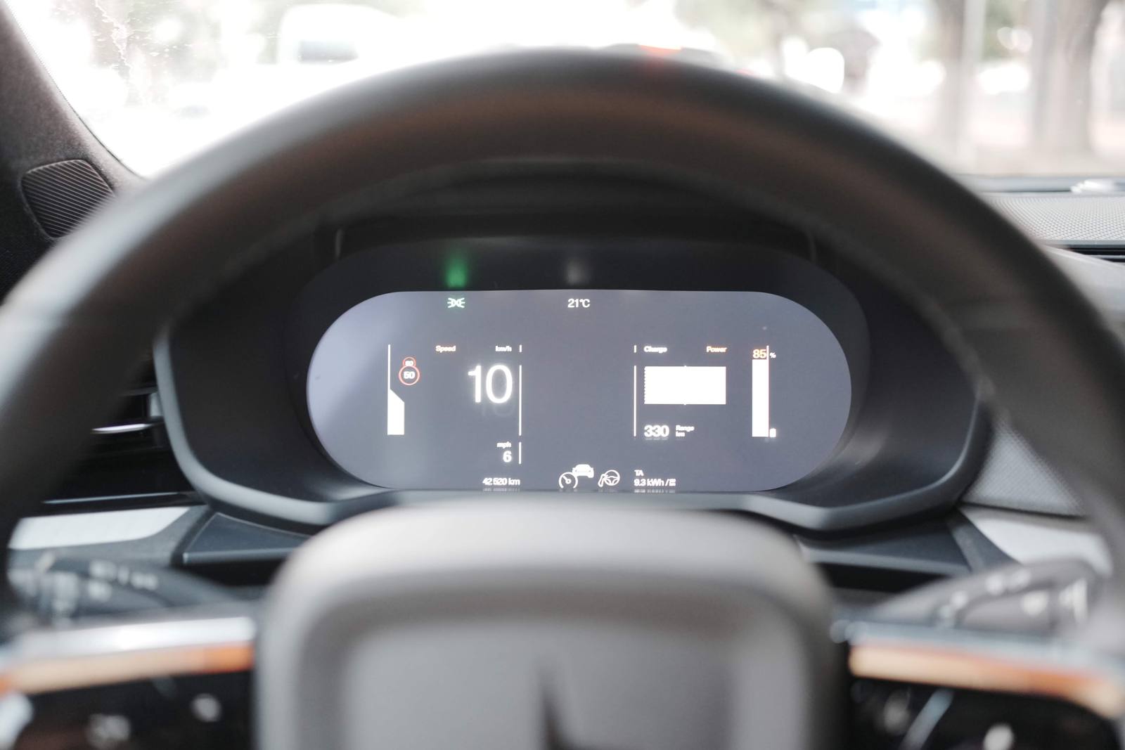 The driver display in Calm mode, at 10 km/h, seen through the steering wheel; in the lower corners, the two stalks